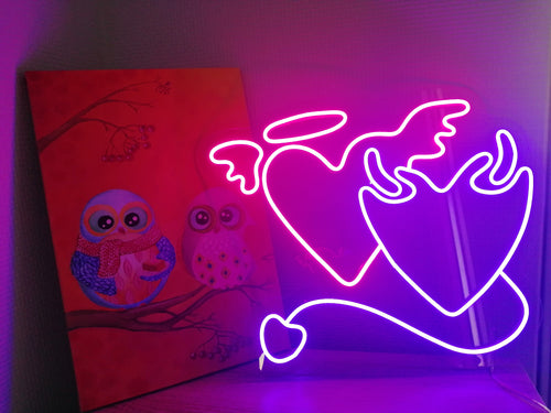 A glowing neon angel and demon heart sign in the same composition with a combination
